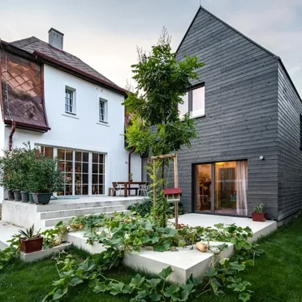 Будинок B від Smartvoll Architects: темно-сіре фарбоване дерево прибудов ще більше привертає увагу до сяючого білого старого будинку. | © Smartvoll Architects / Димитар Гамізов